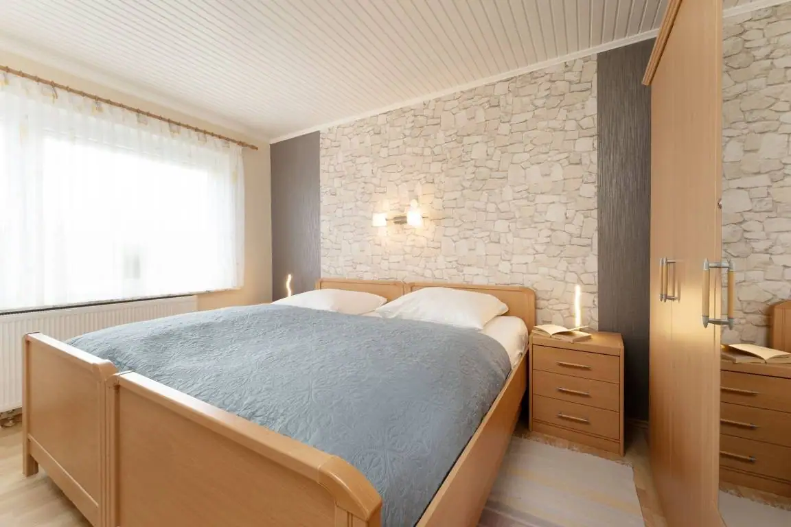 Doppelbett mit blauer Tagesdecke im Schlafzimmer