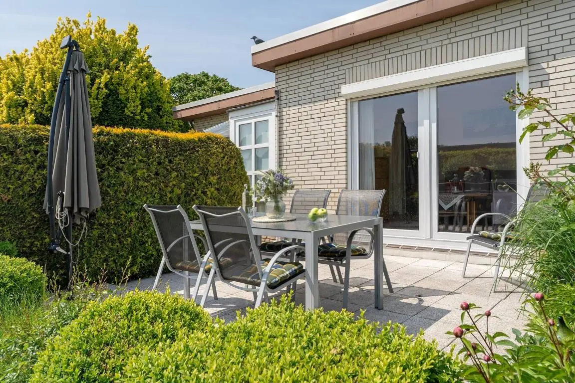Terrasse von Snieder’s Hoeg mit Gartentisch, Sitzplätzen und heller Klinkerfassade