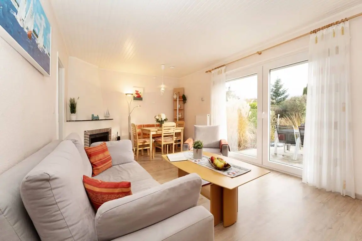Helles Wohnzimmer mit Sofa und Zugang zur Terrasse